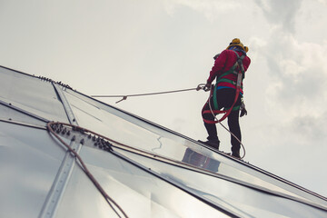 Male workers rope access height safety connecting with eight knots safety harness construction site oil tank dome.