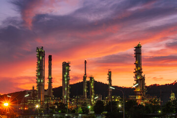 Obraz na płótnie Canvas Oil​ refinery​ and​ plant and tower column of Petrochemistry industry in oil​ and​ gas​ ​industrial with​ cloud​ red​ ​sky the evening​ sunset