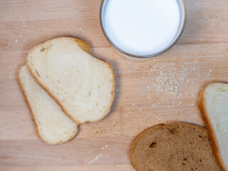 Pieces of rye   bread with a glass of milk on a kitchen board. Healthy breakfast. Bakery products