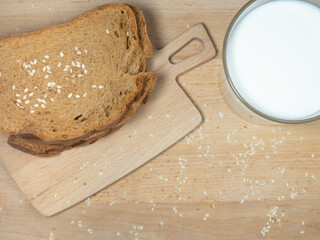 Pieces of rye and white bread with a glass of milk on a plate. Healthy breakfast. Bakery products