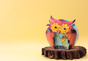 Colorful metallic owl on trunk slice with copy space