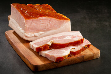 Sliced ​​raw bacon on the table.