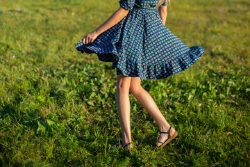 cropped image of legs of woman circling on green grass of summer lawn