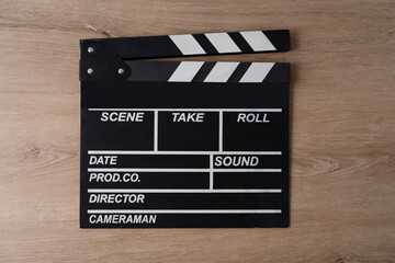 Fototapeta na wymiar movie clapper on wooden table background ; film, cinema and video photography concept