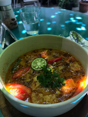 curry rice in a bowl with lime, tempe, tomatoes, pepper, traditional food