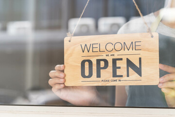 Owner business retail, asian young woman hand in turning sign board to open coffee shop, wearing...