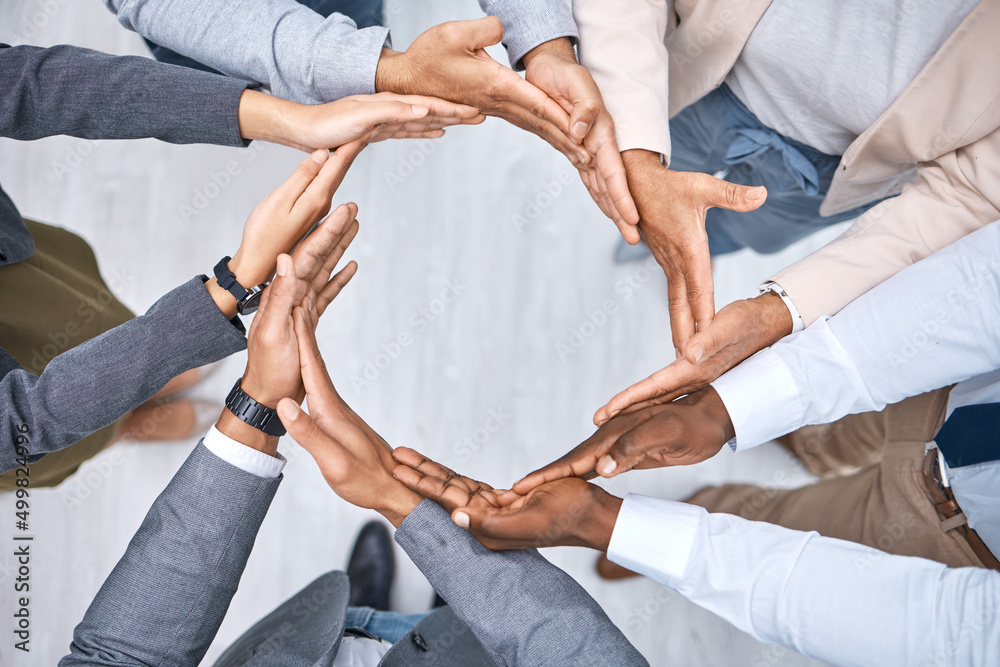 Poster Collaboration helps everything fall into place. Shot of a group of businesspeople joining their hands to form a circle.