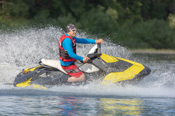 A guy in bright clothes rides a jet ski on the lake. entertainment on a high-speed boat on the...
