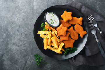 Fish Chips british fast food. Fish Sticks with french fries set on black plate on black table background. Traditional British authentic street food or takeaway food. Mock up with space for text.