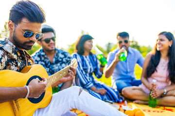 multiethnic people spending time together playing guitar
