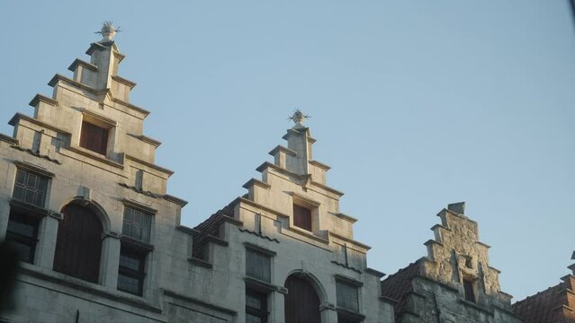 Old European buildings in Belgium during sunset with jet streams time lapse 4k 30p