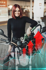Fototapeta na wymiar Shot of happy redhead woman refilling her motorbike in gas station and graphs with price increase.