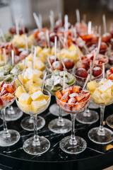 Various fresh fruits and berries in glasses at a party reception. Healthy dessert concept.