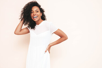 Beautiful black woman with afro curls hairstyle. Smiling model dressed in white summer dress. Sexy...