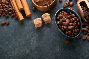 Coffee beans background. Roasted coffee concept with differents types of beans and cinnamon sticks on dark black stone background. Top view. Coffee concept. Mock up.