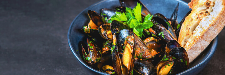 A bowl of delicious steamed mussels with grilled bread.