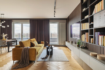 Creative and modern vintage living room interior design with yellow sofa and coffee table on grey carpet. Lamella wall with tv, bookcase and chest of drawers . Herringbone parquet. Template. 
