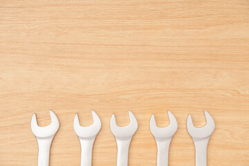 Minimal group of many wrenches or spanners arrange be line with participants means equality of life with wooden background and texture. Equality concept