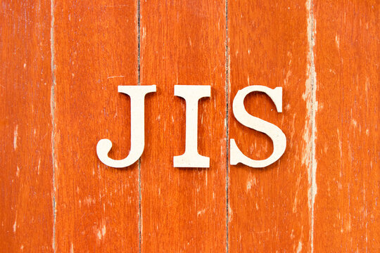 Alphabet letter in word JIS (abbreviation of Just in sequence) on old red color wood plate background