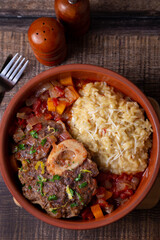 Ossobuco. Veal (beef) shanks with saffron risotto in milanese, gremolata and sauce. Traditional Italian dish. Close-up.