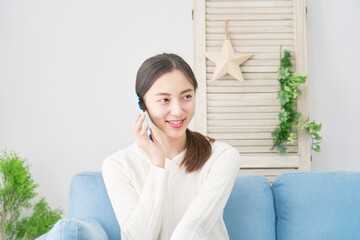 女性　電話する　スマホ　リビング