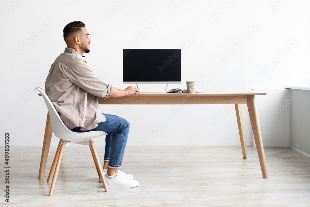 Aufkleber Arab man using computer with blank empty monitor