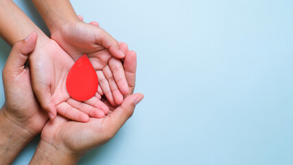 Hands holding blood drop, world blood donor day concept