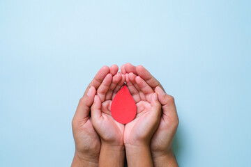 Hands holding blood drop, world blood donor day concept