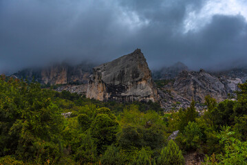 Stony slopes of mountain in dense fog.