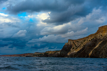 Fototapeta na wymiar rocks of Cape Fiolent against the background of the evening sky with clouds