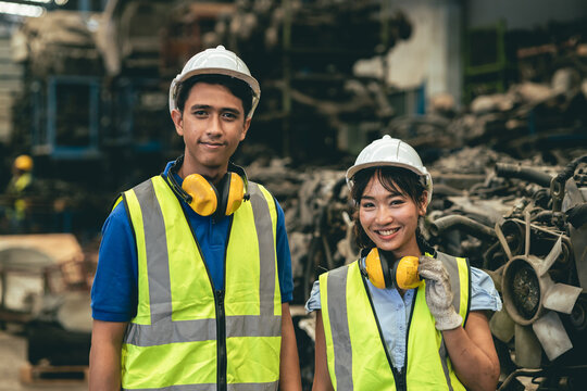 Asian male and woman worker happy working together in heavy industry factory