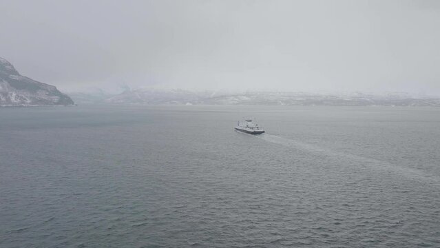 Ferry Sailing Across Kafjord From Olderdalen To Lyngseidet On A Foggy Winter Day In Norway. wide aerial