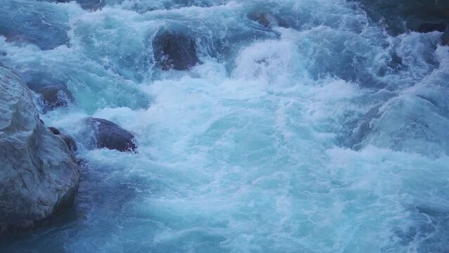 Slow motion shot of the Paravti River flowing in between mountains at Manikaran near Kasol in Himachal Pradesh, India. View of the Parvati river during the winter. Natural river in the mountains.	