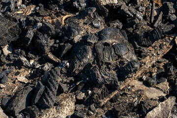 The consequences of a fire in an old wooden country house. Ashes and burnt boards close-up. A fire in a residential wooden house due to arson of dry grass.