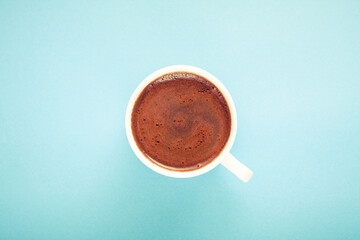 A cup of fresh hot Turkish coffee on blue background.