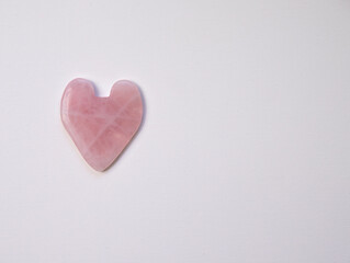 pink heart stone guasha face massage on white background isolate