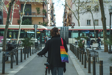 Anonymous gay walking with bicycle on street