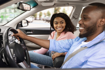 Happy African American couple enjoying drive on new car
