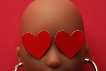 Love and relationship concept. Doll head with two red hearts on eyes. Isolated.