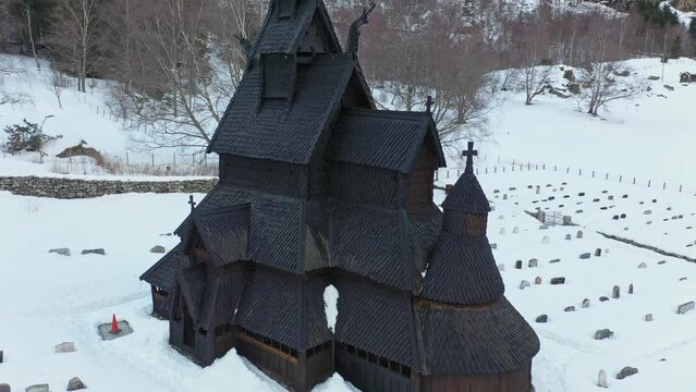 Ancient well maintained Borgund Stave church in Norway - Black historic cathedral from middle age and viking era - Full exterior upward moving aerial view