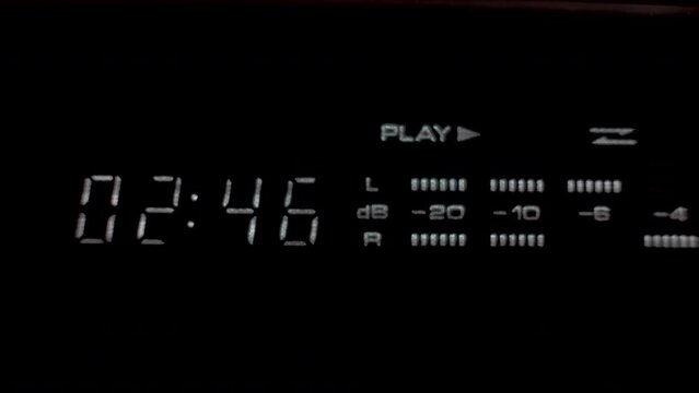 A close up shot of a digital display unit of a Hi fi stereo system, the display providing a time metre and decibel reading as music is played from an old cassette