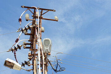 Old electric pole with many wires against the blue sky.close-up