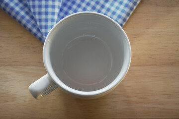 empty white cup on wooden table