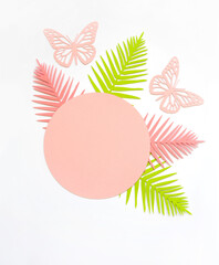 Round Shape Frame with Pink and Green Tropical Leaves on a White Background.Simple Modern Composition with Paper Cut Palm Leaves and Butterflies ideal for Banner, Card,Greetings.Top-Down View.No text.