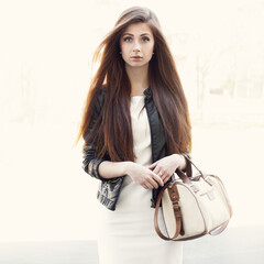 Fashion portrait girl with bag in hand