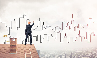 Man architect draw silhouette of modern city on blue sky. Mixed