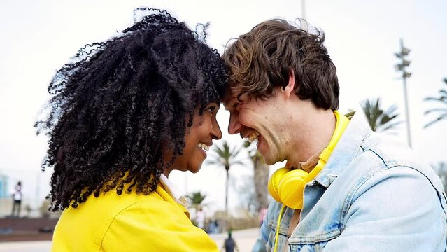 Young multiethnic happy couple spending time outdoor. Latin hispanic girlfriend and caucasian boyfriend sharing love emotions and positive mood in Barcelona. Concept about relatonships and lifestyle