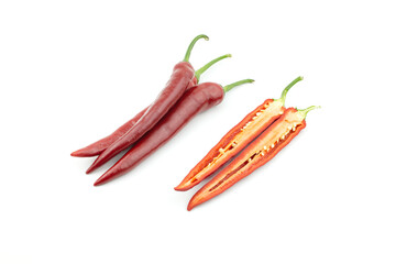 Pile of three fresh raw ripe hot organic red chili peppers whole and one of chilli pepper cut half  isolated on white background clipping path
