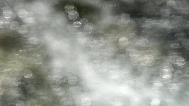 Shiny, flashing circles in flowing water. Abstract silver background with shiny circles.