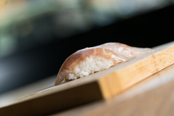 raw sea bass nigiri on wooden cutting board, Japanese cuisine
